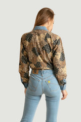 Mujer con look denim con vaqueros y camisa estampada