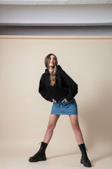 Chica posando con una falda denim corta y con tachuelas
