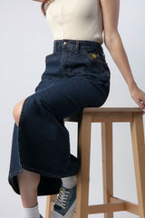 Detalle de una falda denim de color oscuro y larga de pierna