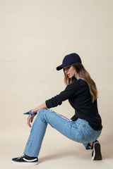 Chica agachada con un pantalón denim azul claro